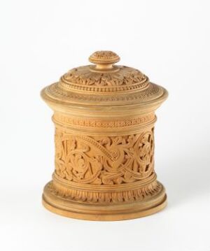  A light beige, intricately carved wooden container with a lid, featuring openwork floral patterns, set against a white background. Artist name and title of the piece are unknown.