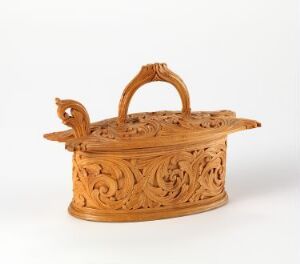  An intricately carved, golden-brown wooden container with a hinged lid and detailed floral and organic motifs throughout, displayed against a neutral background.