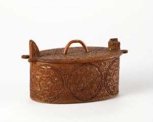  An ornate, copper-brown colored container with embossed circular patterns and a hinged lid with a handle, possibly made of leather or metal, on a plain off-white background.