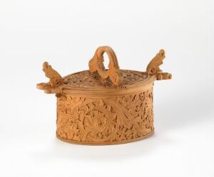  Intricately carved wooden container with a lid, showcasing detailed floral patterns and animal-like figures on the sides, set against a plain, off-white background. Artist and title are unknown.