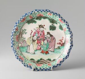  An ornamental plate featuring a painted scene with four Asian-style figures among trees, with a floral rim in vibrant hues of blue, pink, green, and red on a white background. Artist name and title are unknown.