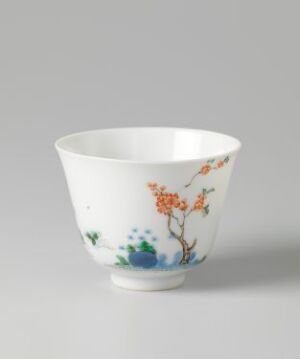  A white porcelain bowl with a hand-painted design featuring orange blossoms on delicately winding branches, along with abstract clusters of blue and green at the base, against a light grey background.