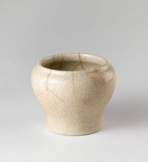  A ceramic pot with a sandy-beige speckled glaze and fine crackled markings on its surface. The pot has a swollen body and a slightly irregular opening, set against a muted, gradient gray background. Artist name and title are unknown.