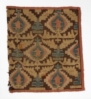  An intricately patterned square textile with symmetrical geometric shapes in earth tones, including sage green, rusty red, beige, and muted teal, with signs of wear along the edges. Artist name and title are unknown.