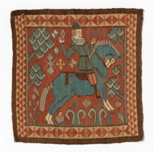  A square ancient textile artifact featuring a stylized human figure in medieval attire dancing or in mid-pose, set against a rusty red background with geometric and abstract motifs in blue, white, and earthy tones, surrounded by a decorative border. Artist name and title are unknown.