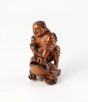  A polished, brown wooden figurine of a laughing, round figure squatting on its haunches with its head tilted back in mirth, holding a small sack, on a neutral white background. Artist name and title are unknown.