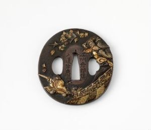  A circular Japanese tsuba hand guard for a sword, crafted in dark metal with a central elliptical opening and two side cutouts, featuring an ornate relief design of a golden-accented tiger and dragon.