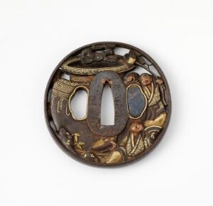  An antique circular bronze-colored button or ornament with an openwork design featuring a stylized letter "M" surrounded by golden-accented decorative patterns, against a light grey background.