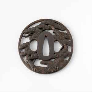 
 A circular, intricately carved object with openwork design in deep brown, possibly wooden, placed against a neutral-colored background.