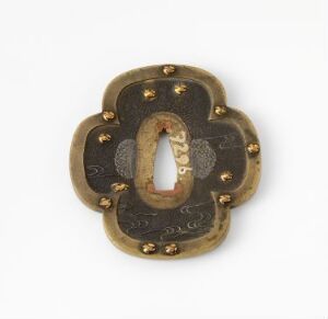  A vintage, floral-shaped bronze or brass keyhole cover with raised petal-like edges and small golden rivets on a light gray background.