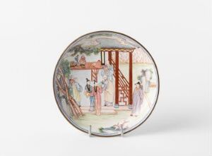  A circular ceramic plate with a white background and Oriental-style painting depicted in soft colors, featuring a scene with historical figures in traditional attire engaging in a social gathering, set within an architectural space with a glimpse of a green garden. Artist and title are unknown.