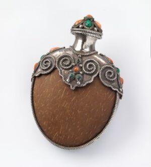  Antique-style egg-shaped perfume bottle with a textured warm brown body and an elaborate silver metal cap, decorated with green and reddish-orange gemstones and fine metallic beading.