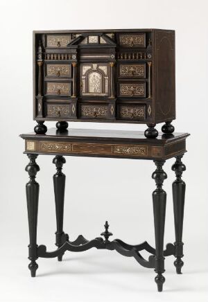  An antique wooden cabinet with compartments and tiny drawers, sitting on a table with decorative inlay, turned legs, and ornamental stretchers, on a neutral background.