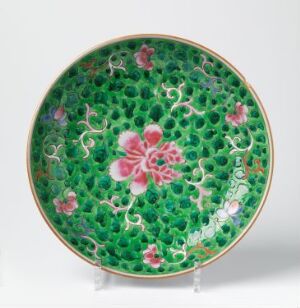  An exquisite Bencharong porcelain plate with vibrant green enamel decorated with a honeycomb pattern and embellished with pink flower motifs, subtle touches of white and yellow, and a red border, artist unknown.