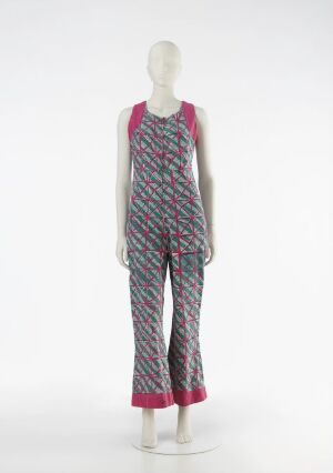  A mannequin dressed in a sleeveless jumpsuit with a vibrant pattern of wavy lines in shades of pink and green, with solid bright magenta shoulder straps and pant hems, displayed against a plain light background.