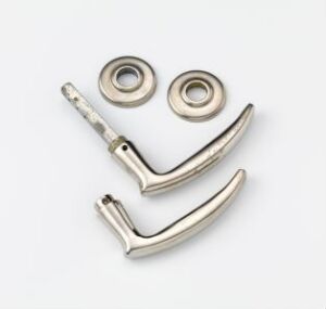  Nr. 2155 («Regjeringsvrideren») by Bjørn A. Larsen, an industrial design object made of cast and screwed metal, arranged on a white background to resemble a smiling face with two round parts as eyes and two curved parts as a smile.