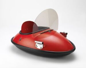  Mørepulken R. Tangen AS's [Uten tittel], a sleek, deep red sports sled with a glossy finish, featuring a semi-circular acrylic windscreen and metallic fixtures on a soft off-white background.