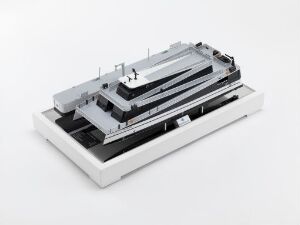  A scale model of a ship titled "Legacy of the Fjords" by Aas Mek. Verksted A/S, presented in monochrome shades of grey and white, featuring tiered decks and a clean, minimalist design on a matte white platform against a grey backdrop.