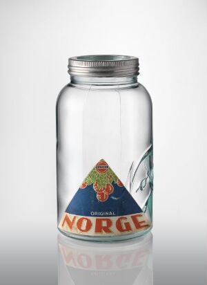  A clear glass jar designed by Hans Berg titled "Norge," featuring a pressed paper label with a Norwegian emblem in red, blue, and gold, and the word "NORGE" in black letters over an orange-to-yellow gradient triangle, set against a white background.