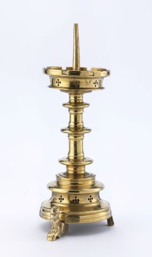  A polished golden brass candlestick or ceremonial stand with an ornate design, highlighted by tiered levels and decorative embellishments, set against a light gray background.