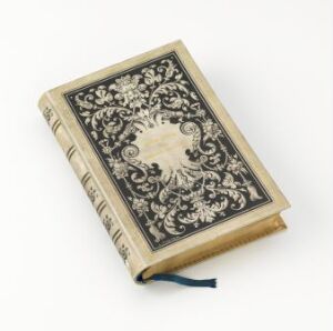  Antique book titled "Die verlorene Handschrift" by artist G. Fritzsche, featuring an ornately designed cover with black symmetrical floral patterns on a light parchment-colored background, cream borders with matching black motifs, yellowed pages, and a blue ribbon bookmark.