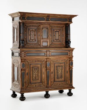  A varnished and stained oak cabinet 'Lintøyskap' by an unidentified artist, featuring ebony, intarsia, and intricate carved details, with engraved iron fittings. The furniture stands on turned legs and exhibits a rich, warm brown color with contrasting darker tones.