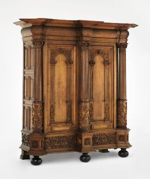  A waxed oak wardrobe, titled "Lintøyskap" by an unidentified artist, showcasing a rich, warm brown color palette with intricate relief carving and profiled decorations, including figurative elements and fluted columns, indicative of traditional design and craftsmanship.