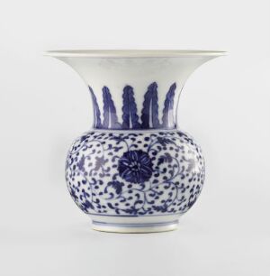 
 A round, bulbous blue and white porcelain vase with stylized blue patterns and a dark blue centered floral motif on a white background.