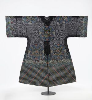  A traditional East Asian dark blue robe with wide, flared sleeves and intricate patterns in green, red, gold, and lighter blues displayed on a stand against a neutral background, likely denoting a historical cultural garment.