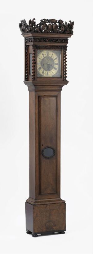  "Gulvur" by Ed. Brookes – An antique longcase grandfather clock made from varnished walnut wood with carved details and turned columns. The clock features a brass dial with decorative brass fittings and wrought iron hands, shielded by a clear glass cover.