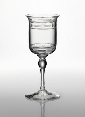  An empty, transparent wine glass with a simple, elegant design, featuring a knopped stem, against a gradient light grey-to-white background.