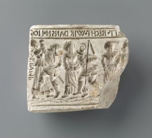  "Bondedans" by unknown artist: An ancient light gray ceramic relief fragment depicting a lively dance or procession with multiple figures, showcasing intricate details and expressive lines indicative of movement, on a neutral background.