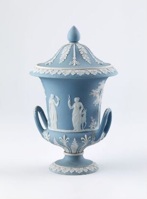 
 Antique pastel blue urn with white bas-relief classical figures and decorative leaf patterns, featuring elegantly curved handles and a decorative lid. Artist and title are unknown.