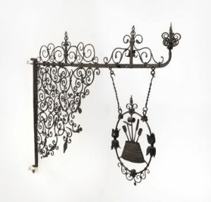  An ornate black wrought iron brewery sign titled "Bryggeriskilt" by an unidentified manufacturer, with elaborate scrolls and a central emblem featuring a cauldron and floral elements, mounted against a white background.