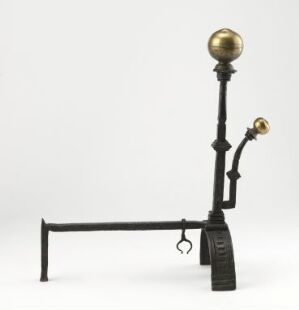  An antique scale with a vertical black stand featuring a golden brass sphere on top and a small brass plate on a horizontal arm, set against a light grey background. Artistname and title are unknown.