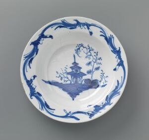  A decorative blue and white porcelain plate featuring a central Asian-style pagoda scene, with surrounding stylized natural motifs, and an ornately designed rim. The artist's name and title of the work are unknown.