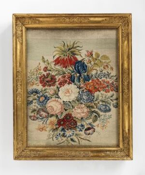  A framed floral artwork featuring an intricately designed bouquet with a wide range of colorful flowers, including reds, pinks, blues, and purples, set against a beige textile background, within a gold ornate frame. Artist and title unknown.