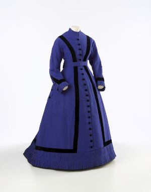  A royal blue vintage dress with long sleeves and black trim on a mannequin against a neutral background.