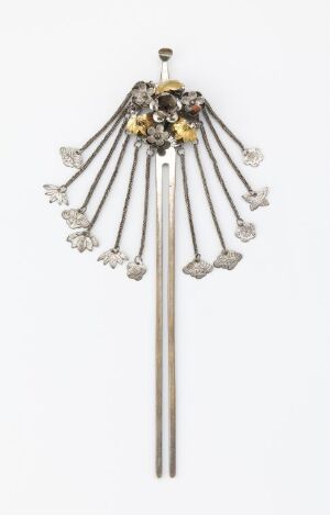  A silver-toned brooch designed to resemble a fountain or firework display, with thin metal rods in a fan arrangement, capped with sparkling elements and gold accents, centered around a decorative clasp.