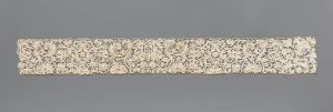  A narrow, intricately patterned, horizontal panel with lace-like floral designs in a creamy, off-white color set against a neutral grey background. Artist name and title are unknown.