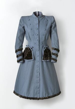  A vintage-style blue women's coat with a flared skirt, stand-up collar, double row of navy buttons, dark blue and black striped cuffs, and plush dark blue velvet pockets with black trim, displayed on a neutral background.