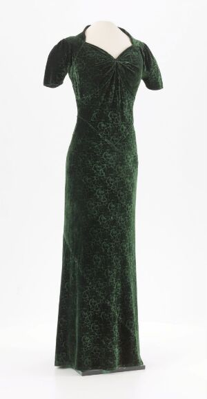  An elegant, floor-length, deep emerald green evening dress with a low-cut V-neck and off-the-shoulder short sleeves, displayed against a plain light background.