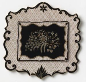  An ornamental piece with a scalloped, beige frame featuring subtle patterns and decorative elements, enclosing a rich black center adorned with a golden floral design.