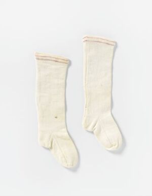  A pair of off-white traditional dress socks with fold-over cuffs, displayed against a light background, suggesting historical or formal usage.