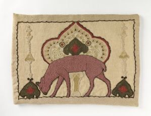  A textile artwork showing a stylized pink elephant under an ornate canopy-like design, with smaller symmetrical motifs in the bottom corners, all set against a beige fabric background.